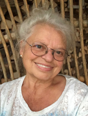 Foto von Roswitha Hodapp mit weisser Bluse grinst Sie mit einer Brille auf in die Kamera